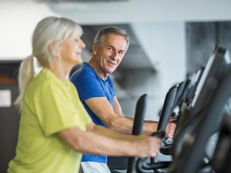 elderly couple walking on treadmills