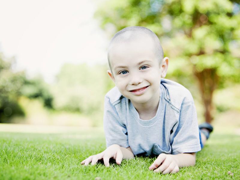 a small child laying in the grass smiling
