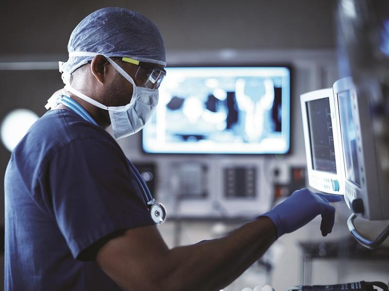 Image of surgeon at screen in operating room.