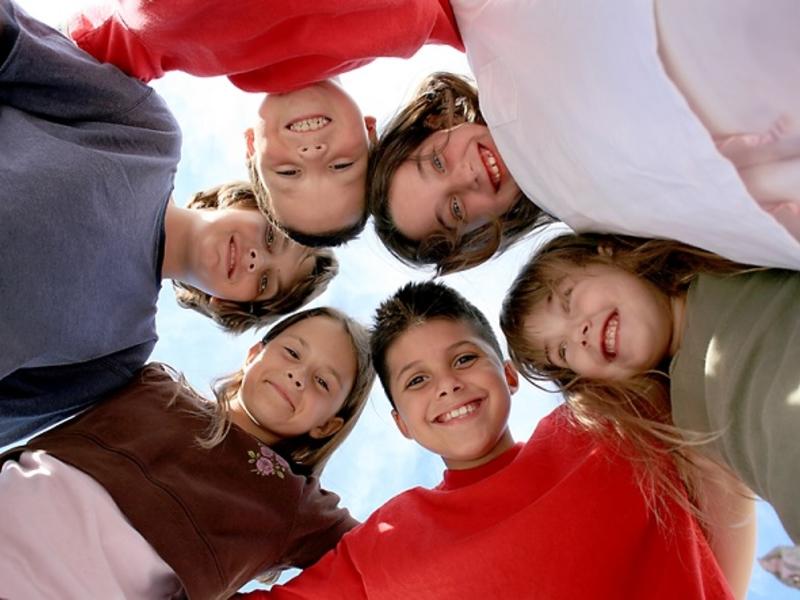 Group of children in circle looking at camera.