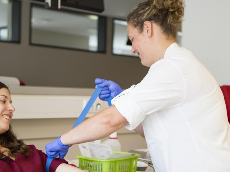 Phlebotomist drawing blood from patient.