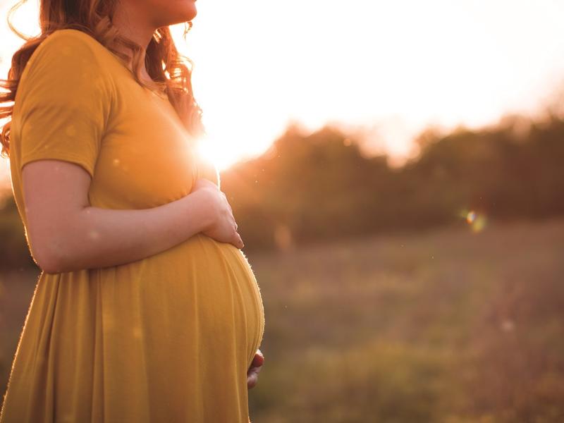 Pregnant woman in field.