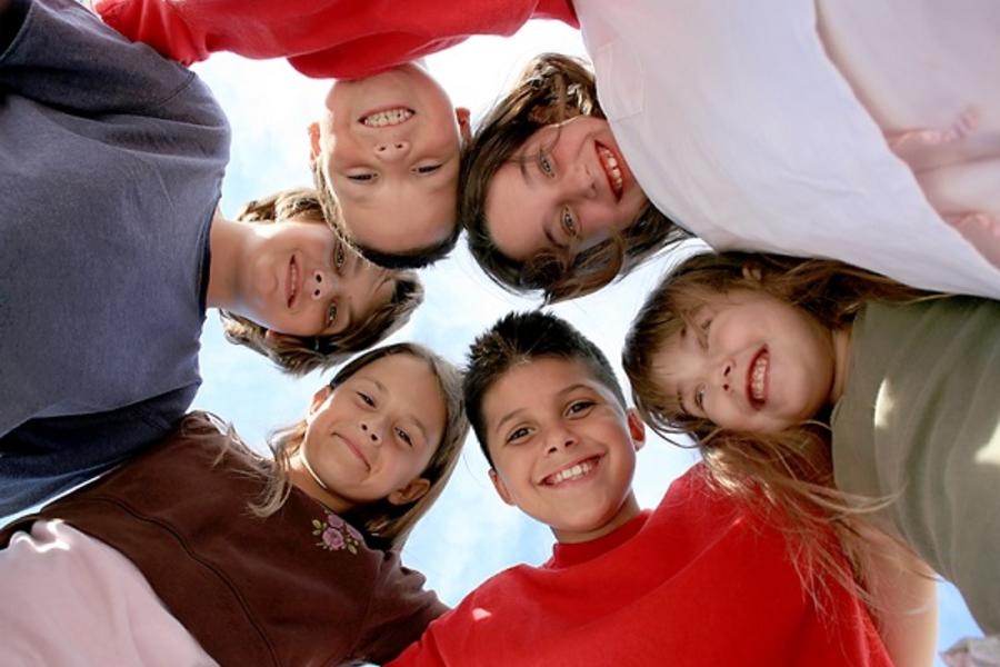 Group of children in circle looking at camera.