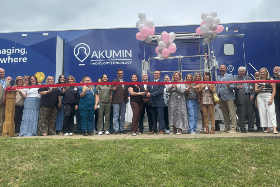Employees about to cut the ribbon on the new scanner