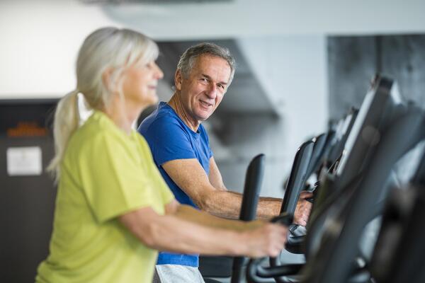 elderly couple walking on treadmills