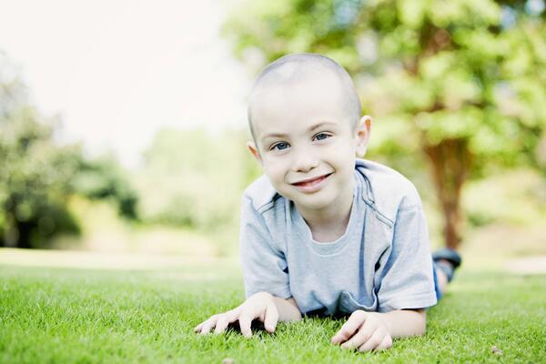 a small child laying in the grass smiling