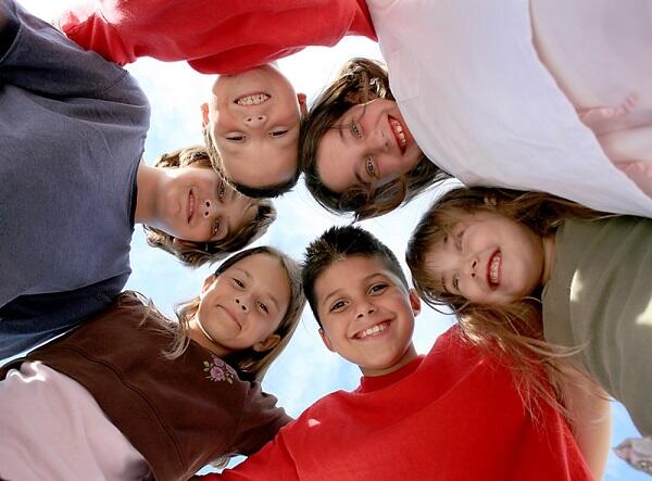 Group of children in circle looking at camera.
