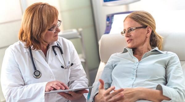 Doctor speaking with patient in chair