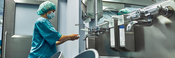 Surgical setting showing care provider sterilizing hands 